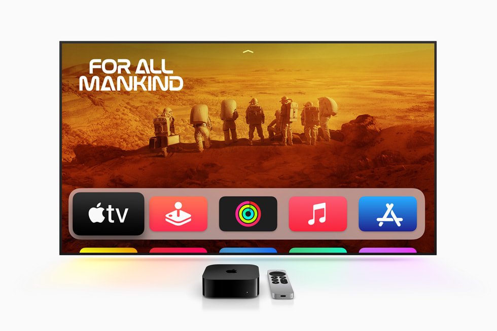 Apple TV 4K și telecomanda Siri Remote în fața unui televizor care afișează interfața tvOS