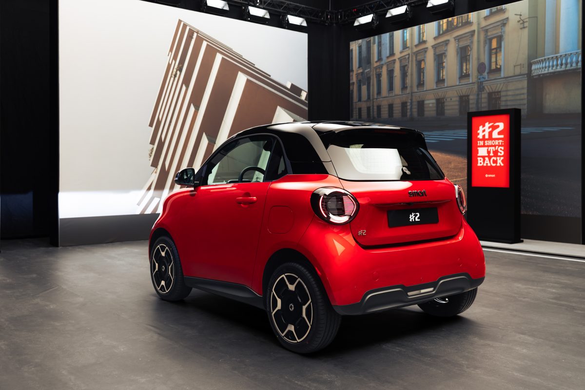 Smart #2 Premium roșu cu plafon negru, văzut din spate, într-un decor de stradă
