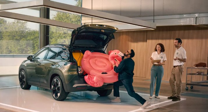 Portbagajul deschis al unui Volkswagen ID. Cross, în care este încărcat un colac gonflabil roz în formă de flamingo