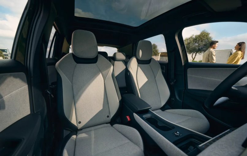 Scaunele față ale unui Volkswagen ID. Cross, tapițate în material textil deschis la culoare, cu plafonul panoramic deasupra